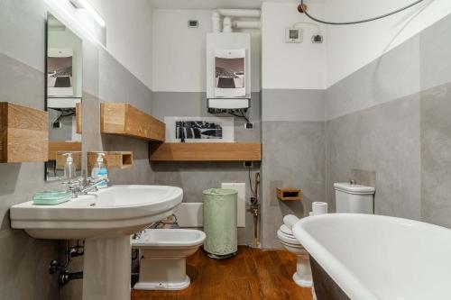 a bathroom with a sink and a tub and a toilet at L'affresco in Via Guinigi in Lucca