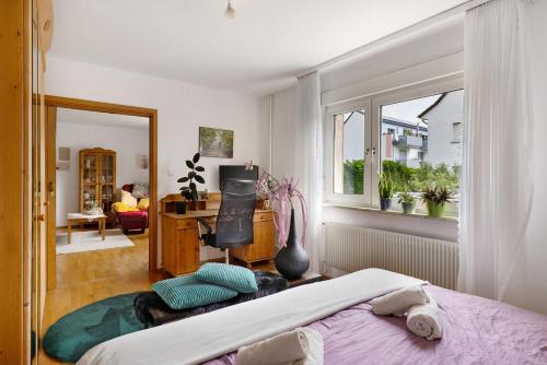 a bedroom with a bed and a desk and a window at Fewo Sartorius in Bensheim