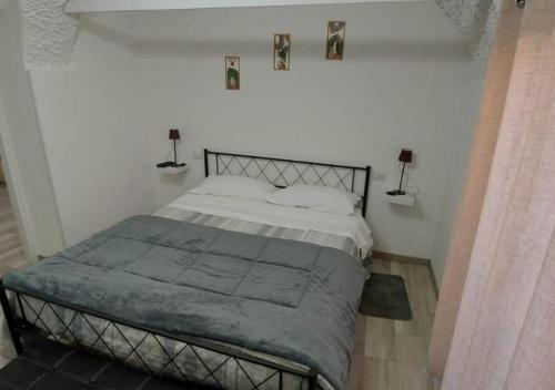 a bed in a white bedroom with two lamps at Casa Elena in Ventimiglia