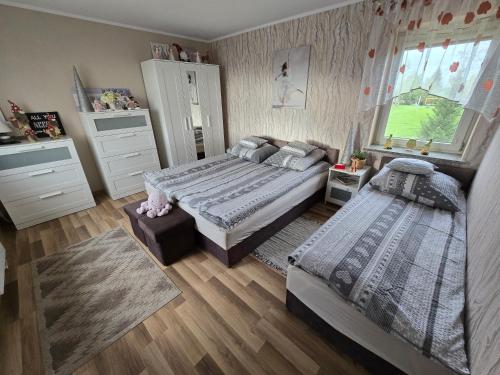 a bedroom with two beds and a window at Dom wypoczynkowy Radomno in Radomno