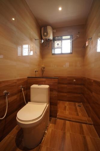 a bathroom with a toilet in a room with wooden walls at v square inn in Visakhapatnam