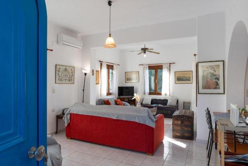 a living room with a red couch in a room at Arto's Villa With Private Pool- BY APOKORONAS VILLAS in Plaka