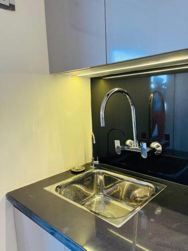 a kitchen sink with a faucet on top of it at Cozy haven in Greater Noida
