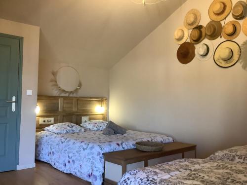 two beds in a room with hats on the wall at Au duplex in Chantonnay