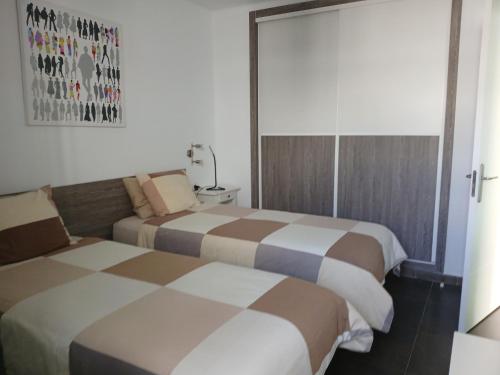 a room with two beds in a room at Departamento Barcaro 2 in Puerto del Carmen