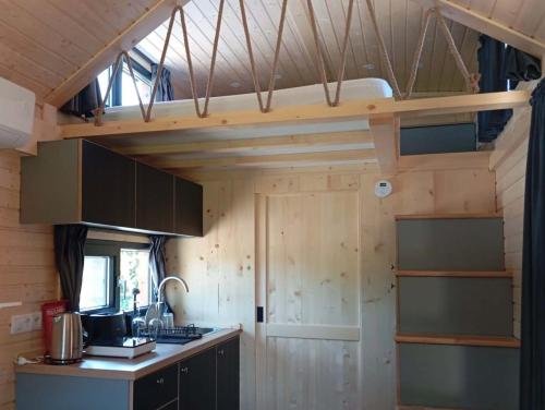 a kitchen with a loft bed in a tiny house at Casa do Cipreste by Tiny Away in São Teotónio