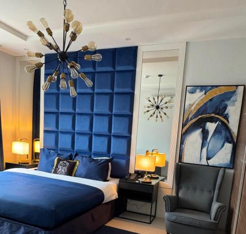 a blue bedroom with a bed and a chair at دانة الرياض للشقق المخدومة2 - Dana Serviced Apartments2 in Riyadh
