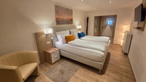 a bedroom with a bed and a couch and a chair at Gasthaus Pension Moselgruss in Dieblich