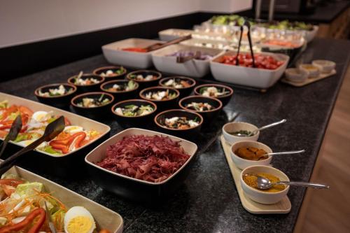 a buffet with many different dishes of food on a table at Hotel Comtes d'Urgell by Nexta in Andorra la Vella