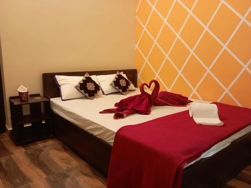 a bedroom with a bed with a red blanket on it at Adb's Arangan Kudil Homes in Tiruchirappalli