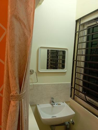 a bathroom with a sink and a window at Adb's Arangan Kudil Homes in Tiruchirappalli