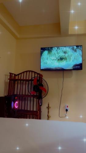 a flat screen tv on the wall of a bedroom at Leisure guest in Diani Beach