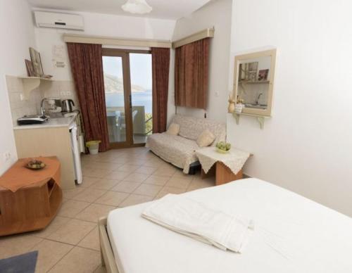 a bedroom with a bed and a living room at Dimitrakis Studios in Masouri