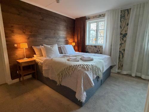 a bedroom with a large bed with a wooden wall at Strandlogiet Ljugarn in Ljugarn
