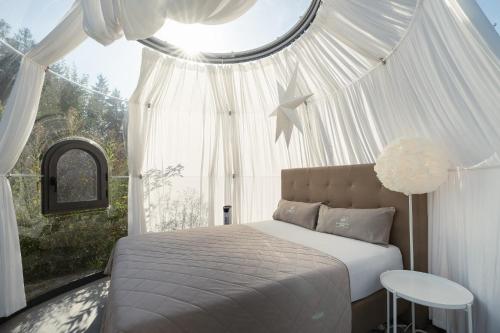 a bedroom with a bed and a large window at Chalet Weidehaus De Luxe in Obertriesting