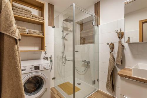 a bathroom with a shower and a washing machine at Haus Kali in Teisendorf