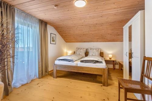 a bedroom with a bed and a wooden ceiling at Haus Kali in Teisendorf