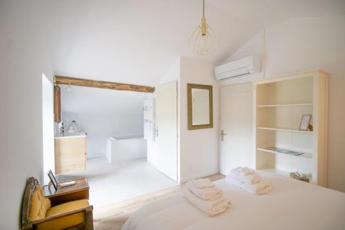 a white room with a bed with towels on it at A Casa D'amore in Bastelica