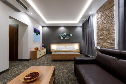 a living room with a bed and a couch at Hotel Garzon Plaza in Győr