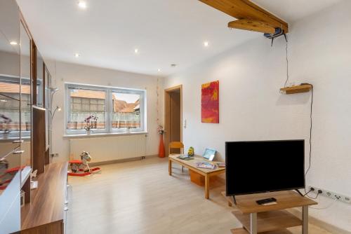 a living room with a flat screen tv and a table at Ferienwohnung Sonnenblume in Rhadern