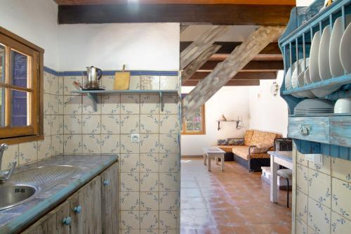 a kitchen with a sink and a living room at Casa Azul - Vejer, El Palmar in Vejer de la Frontera