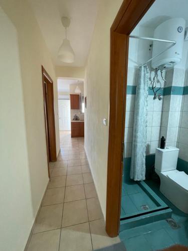 a hallway of a bathroom with a shower and a sink at Almond Apartments in Orfánion