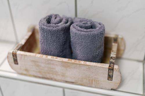 a wooden holder with three purple towels in a bathroom at Casa Bianca in Offenburg
