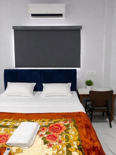 a bedroom with a large bed with a blue headboard at Chouhan Resort in Katihār