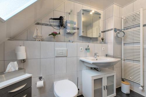a white bathroom with a toilet and a sink at Micha's Ferienwohnung in Bredstedt