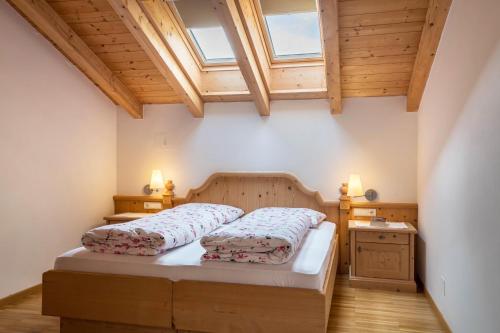 a bedroom with a bed and a wooden ceiling at Funtnatsch Apartment Schlern in Laion