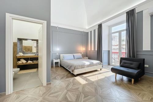 a bedroom with a bed and a chair and a mirror at Orchidea Celeste Bed and Breakfast in Manfredonia