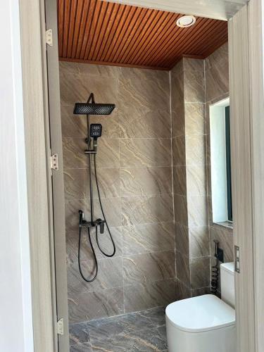 a bathroom with a shower and a toilet in it at Quỳnh s House in Tân Hiệp