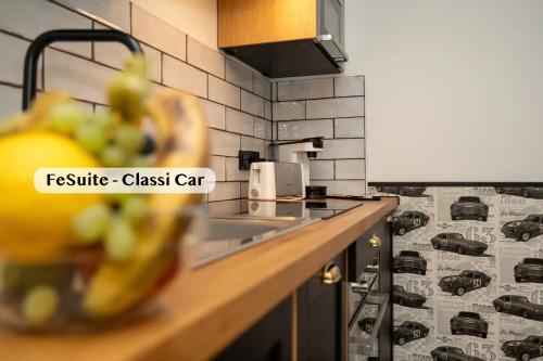 a kitchen counter with a sink and a bowl of fruit at Boutique Suites anno 1789 by Kamelu in Gengenbach