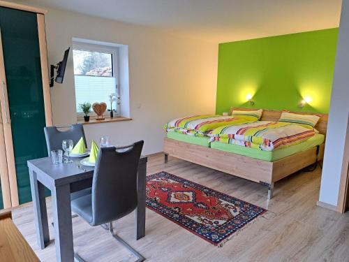 a bedroom with a bed and a desk and a table at Ferienwohnung Abendsonne in Nagel