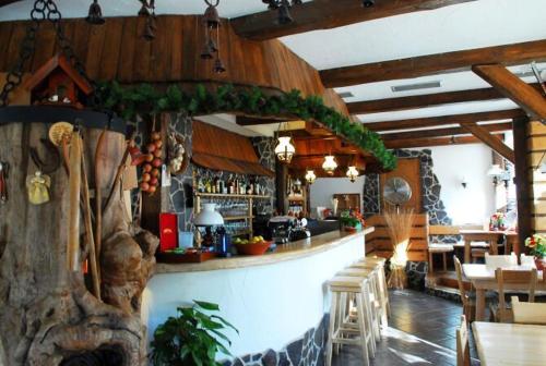 a restaurant with a bar and tables and chairs at Penzion Daniela in Rajecké Teplice