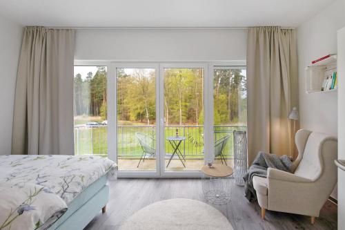 a bedroom with a bed and a view of a balcony at Lieblingsinsel in Graal-Müritz