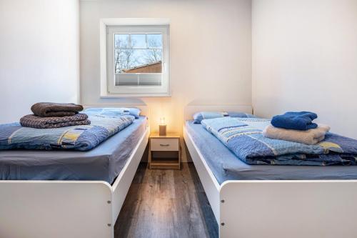 two beds in a small room with a window at Ferienwohnung Leuchtturm in Osterbruch