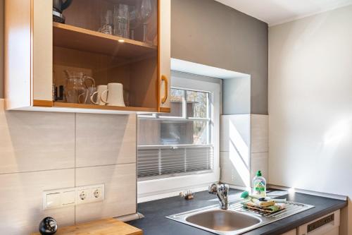 a kitchen with a sink and a window at Ferienwohnung Leuchtturm in Osterbruch