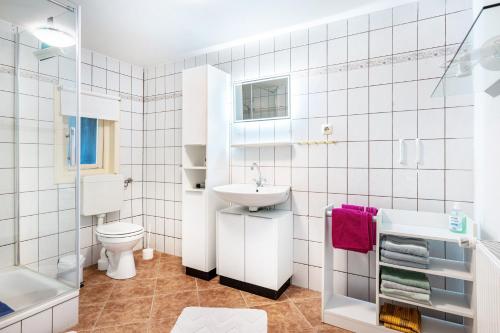 a white bathroom with a sink and a toilet at Ferienhaus Himmelreich in Barlt
