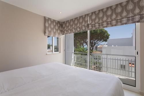 a bedroom with a bed and a large window at Villa Leeroy in Almancil