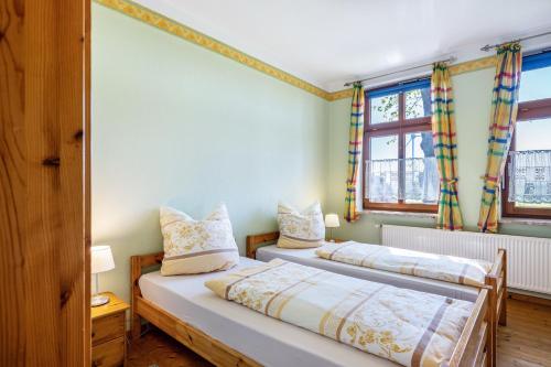 two beds in a room with two windows at Ferienhaus Himmelreich in Barlt