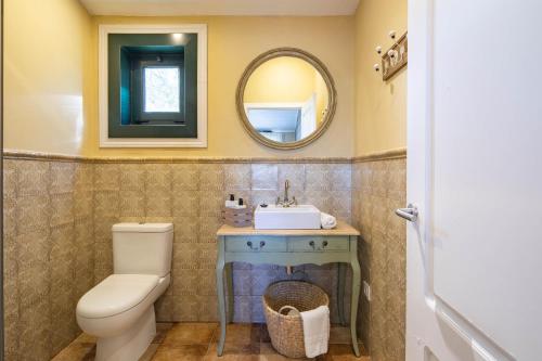 a bathroom with a toilet and a sink and a mirror at Apartamento La Calleja in Arzúa