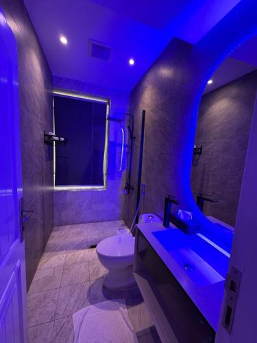 a bathroom with a toilet and a sink and a blue light at دانة الرياض للشقق المخدومة2 - Dana Serviced Apartments2 in Riyadh