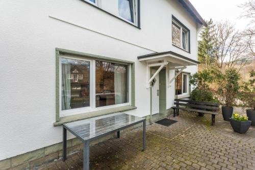 a glass table outside of a building with a bench at Ferienwohnung Greitemann in Eslohe
