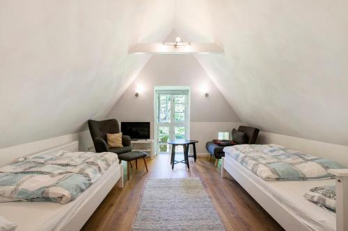 a attic bedroom with two beds and a desk at Ferienhaus Reetkate Breklum in Breklum