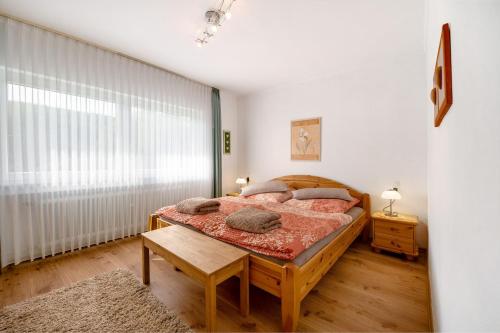 a bedroom with a large bed and a table at Ferienwohnung Tibo in Wimbach