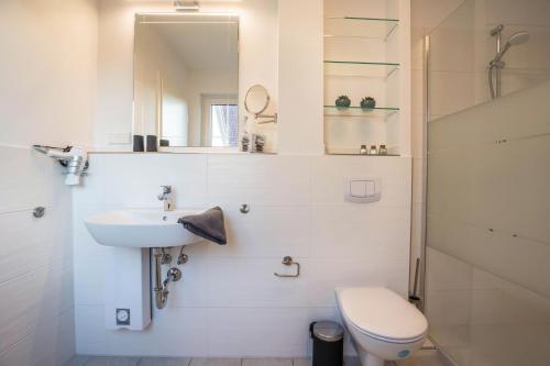 a white bathroom with a sink and a toilet at Ferienhaus Spaden in Spaden