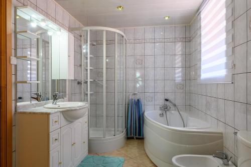 a bathroom with a tub and a sink and a bath tub at Villa Balboa in Sondernach