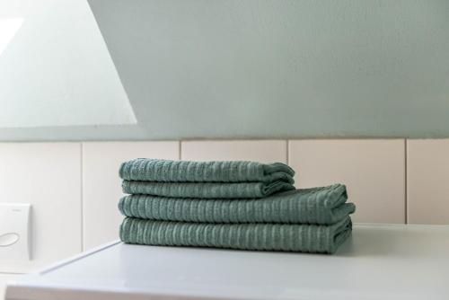 a stack of green towels on a counter in a bathroom at Marienstraße, 54m², ruhig gelegen in Herdwangen-Schönach