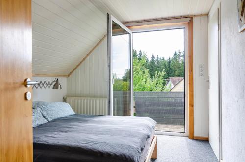 a bedroom with a bed and a large window at Marienstraße, 54m², ruhig gelegen in Herdwangen-Schönach